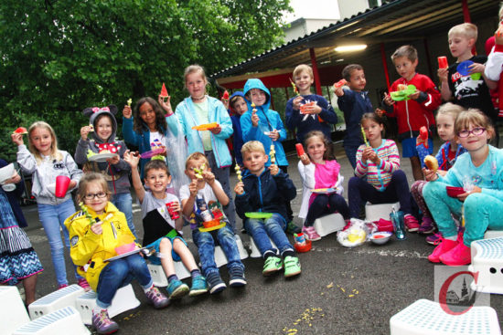 Kaum waren die Stühle draußen und in die erste Möhre, Apfel oder Obst-Spieß gebissen, machte der Regen dem gesunden Pausenhof-Frühstück auch schon wieder ein Ende – aber in den Klassen schmeckte es bestimmt genauso gut… -Foto: Meinhard Koke